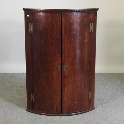 Lot 511 - A bow front corner cabinet