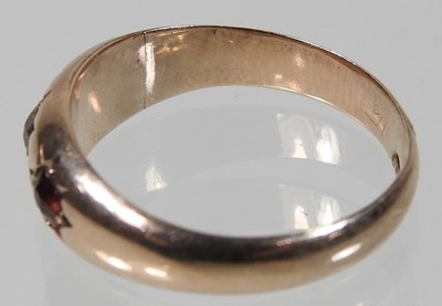 Lot 26 - A 9 carat gold three stone garnet ring