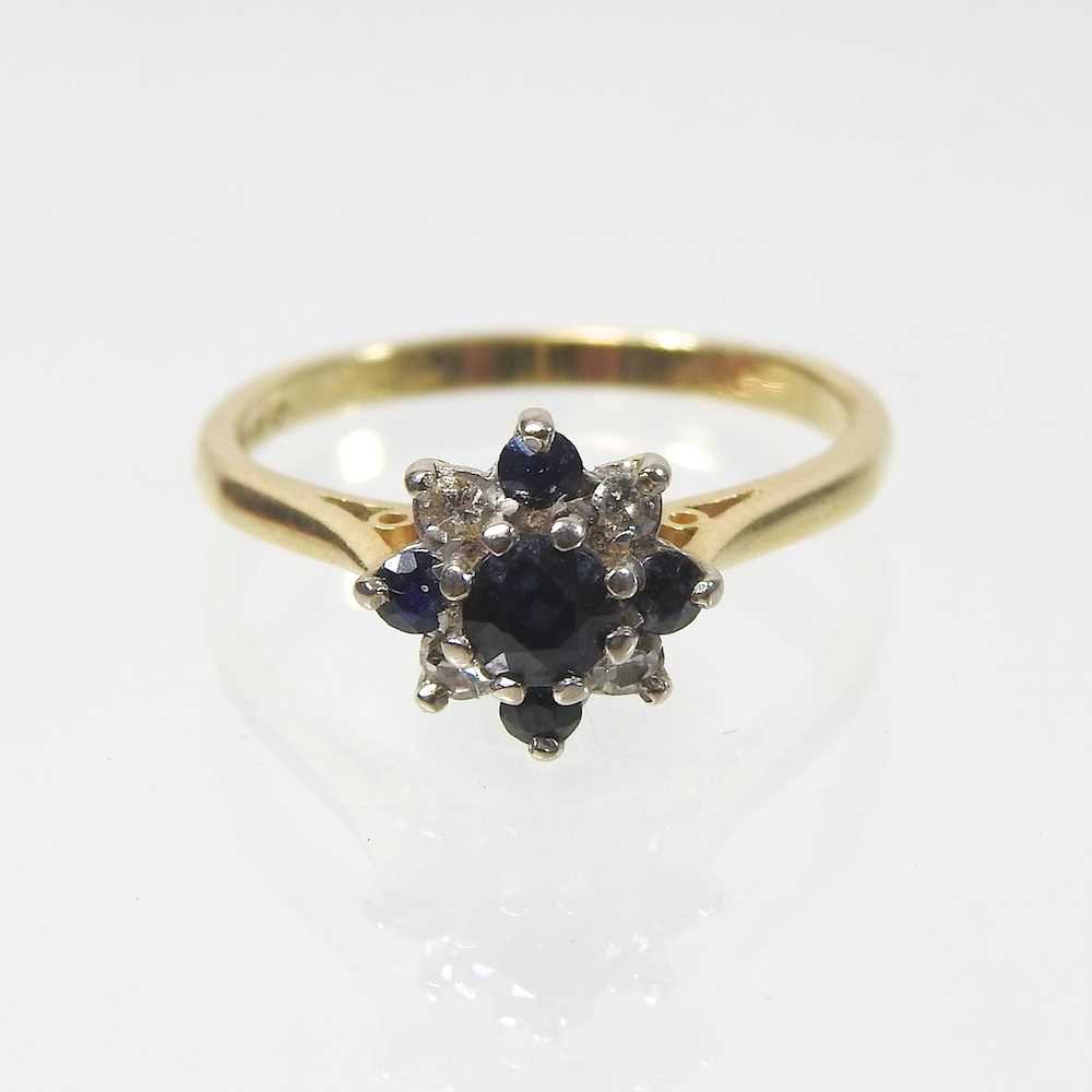 Lot 19 - An 18 carat gold sapphire and diamond cluster ring