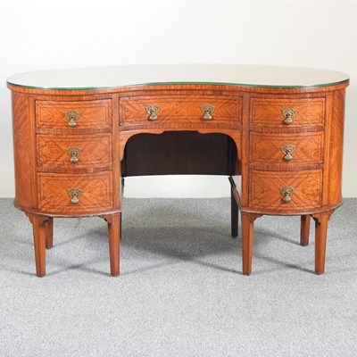 Lot 285 - An Edwardian satinwood kidney shaped desk