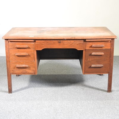 Lot 124 - A mid 20th century light oak desk