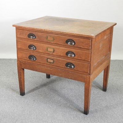 Lot 457 - A 1920's oak plan chest, on stand