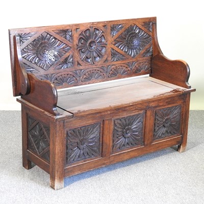 Lot 552 - A carved oak monks bench