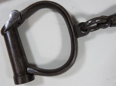 Lot 9 - A pair of antique handcuffs and baton