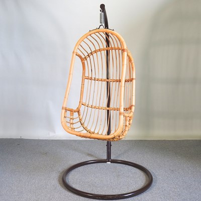 Lot 558 - A bamboo egg shaped hanging chair, on a metal...