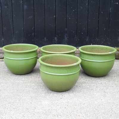 Lot 648 - A set of four large green glazed garden pots,...