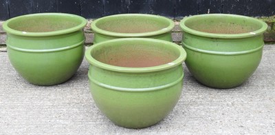 Lot 648 - A set of four large green glazed garden pots,...