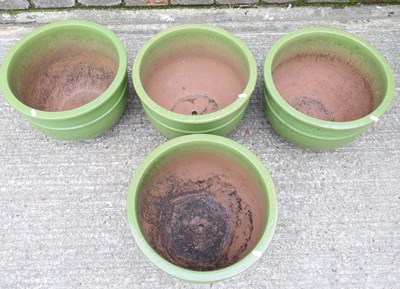 Lot 648 - A set of four large green glazed garden pots,...