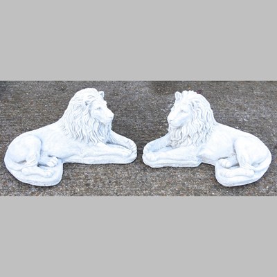 Lot 471 - A pair of cast stone models of recumbent lions,...