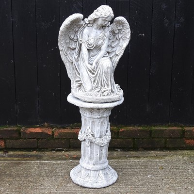 Lot 663 - A cast stone garden statue of an angel on a...