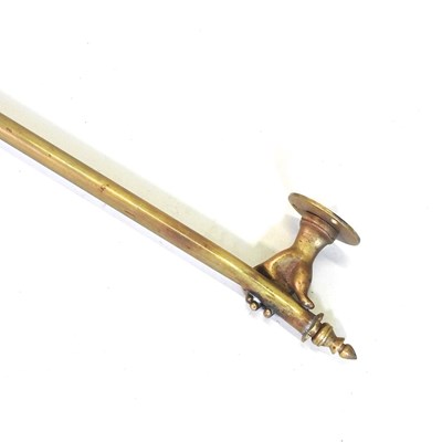 Lot 18 - A brass curtain pole, the supports in the form...