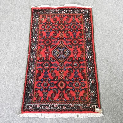 Lot 524 - A Persian woollen rug, on a red ground, 122 x...