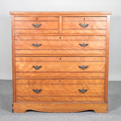 Lot 589 - A large Edwardian maple chest of drawers, on a...