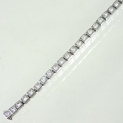 Lot 11 - An 18 carat white gold diamond line bracelet,...