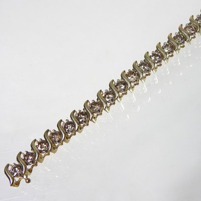 Lot 74 - A 14 carat gold diamond line bracelet, set...