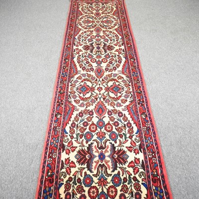 Lot 179 - A Persian runner, with foliate motifs, on an...