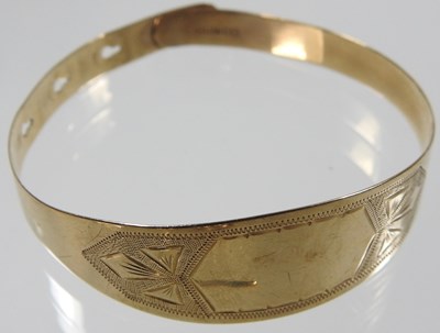 Lot 554 - A 9 carat gold bangle, with engraved...