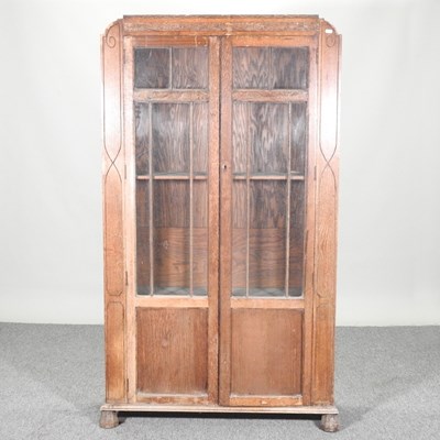 Lot 429 - A 1920's glazed oak bookcase, on turned feet