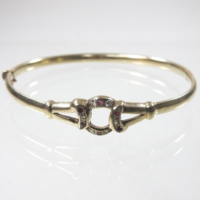 Lot 19 - A 9 carat gold hinged bangle, set with rubies...