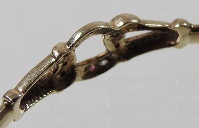 Lot 19 - A 9 carat gold hinged bangle, set with rubies...