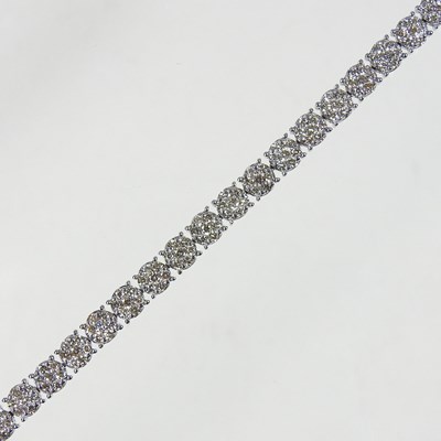 Lot 413 - A 9 carat white gold diamond set line bracelet,...