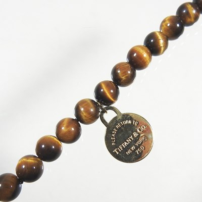 Lot 570 - A Tiffany & Co. tiger's eye single strand bead...