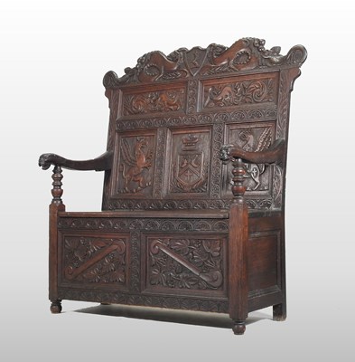 Lot 248 - A 19th century heavily carved dark oak box settle