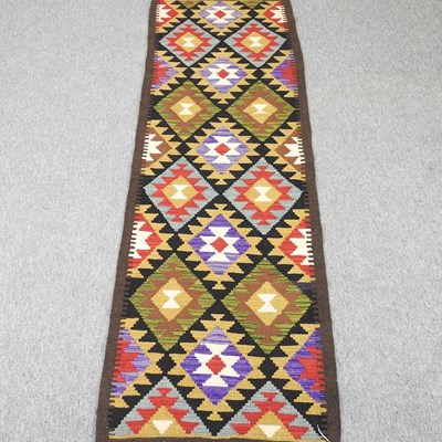Lot 87 - A kilim runner, with rows of coloured diamonds,...