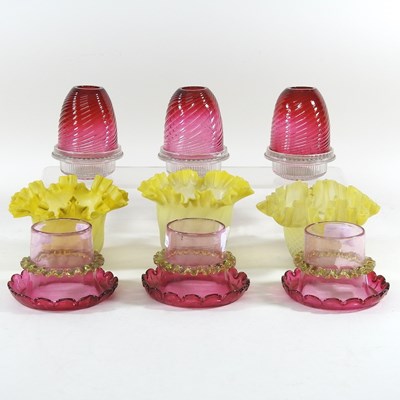 Lot 607 - A set of three cranberry glass shades, the...