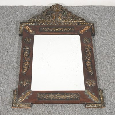 Lot 102 - An ornate wall mirror, with embossed metal...
