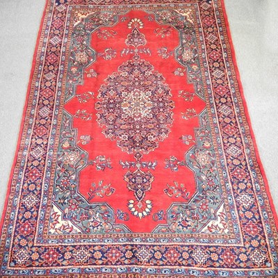 Lot 355 - A Persian carpet, with a large central red...