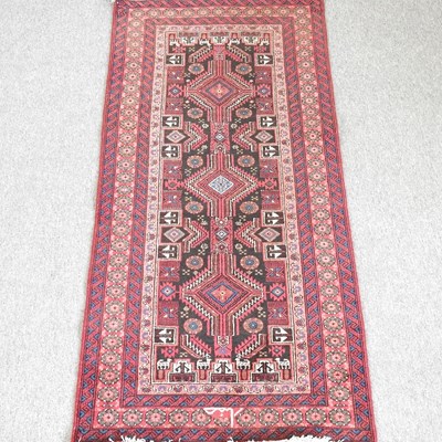 Lot 427 - A Persian rug, with a row of three central...