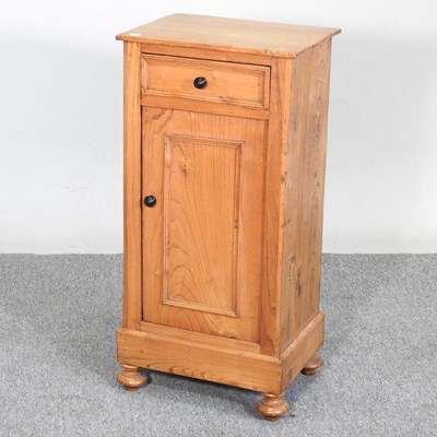 Lot 139 - A light elm bedside cupboard, containing a...