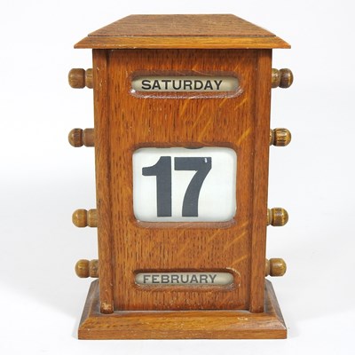 Lot 4 - An early 20th century light oak desk calendar,...