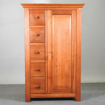 Lot 382 - A modern pine single wardrobe, with drawers to...
