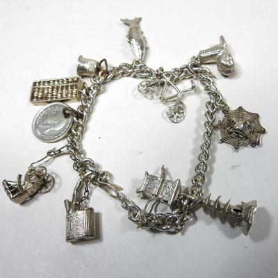 Lot 25 - A charm bracelet, suspended with novelty...