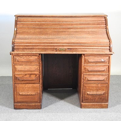 Lot 322 - A 1920's oak tambour top pedestal desk, with a...