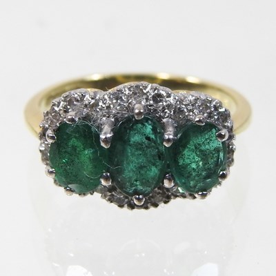 Lot 112 - An 18 carat gold emerald and diamond triple cluster ring