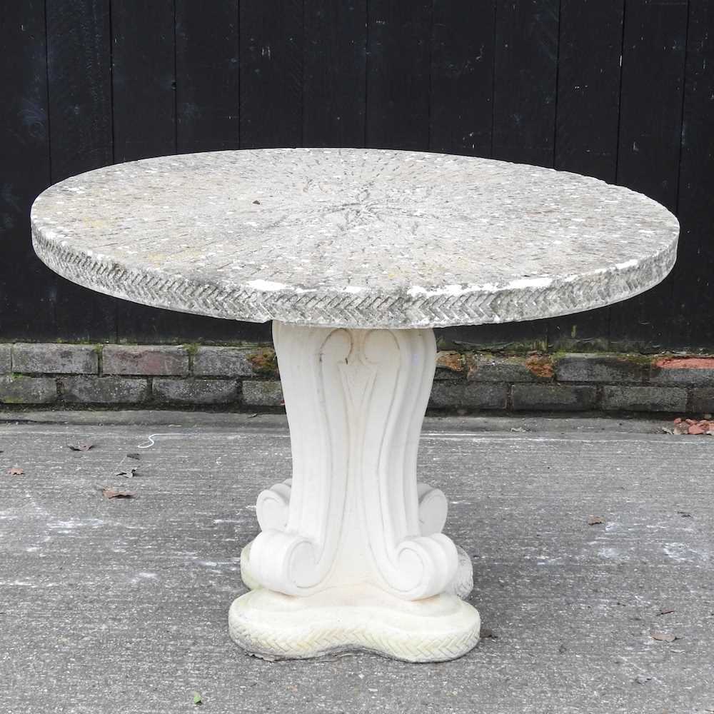 Lot 47 - A cast stone circular garden dining table, on...