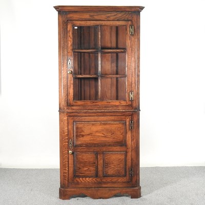Lot 233 - A modern oak standing corner cabinet, with a...