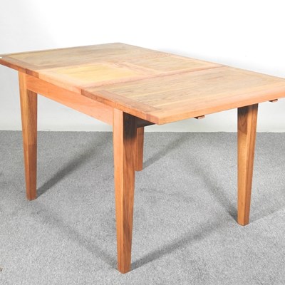 Lot 516 - A modern light oak draw leaf dining table