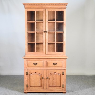 Lot 390 - A modern light oak glazed cabinet bookcase