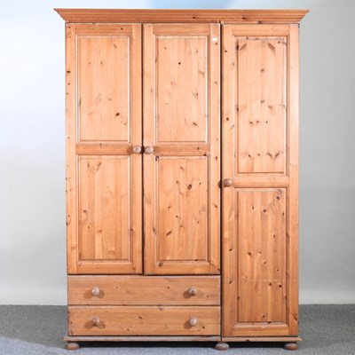 Lot 133 - A modern pine triple wardrobe, with drawers below