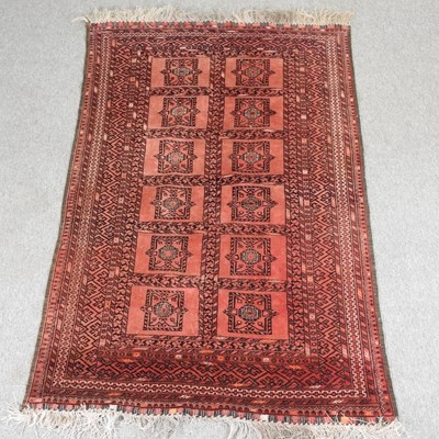 Lot 192 - An Afghan woollen rug, with two rows of...