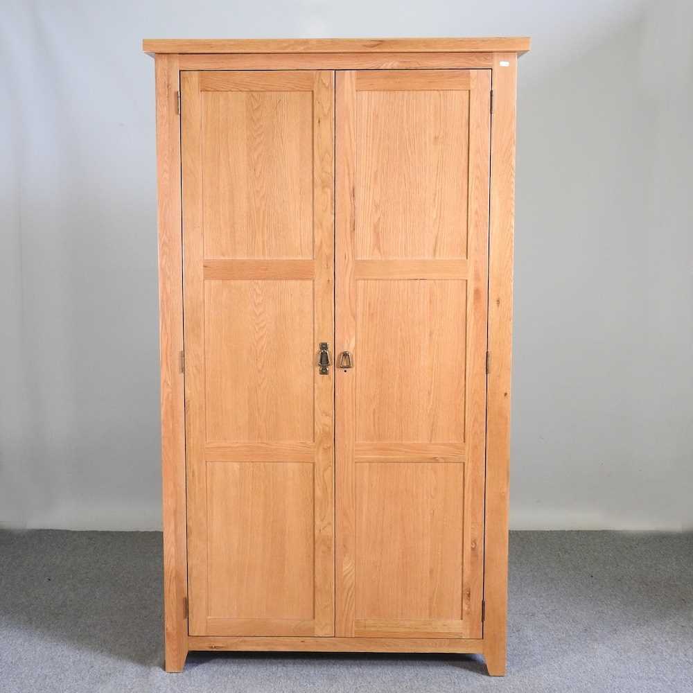 Lot 337 - A modern light oak double wardrobe