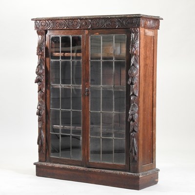 Lot 386 - A 19th century heavily carved dark oak glazed dwarf bookcase