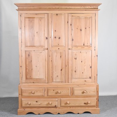 Lot 313 - A modern pine triple wardrobe, with an...