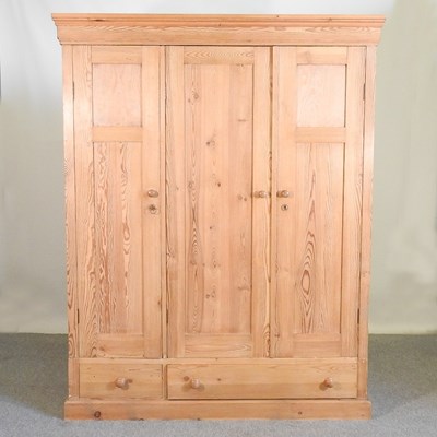 Lot 194 - A pine triple wardrobe, with two drawers below