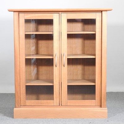 Lot 349 - A modern light oak glazed cabinet, on a plinth...