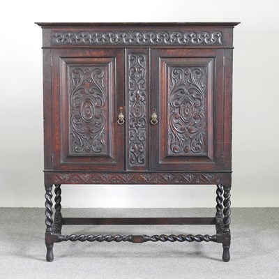 Lot 683 - An early 20th century carved oak cabinet, on...